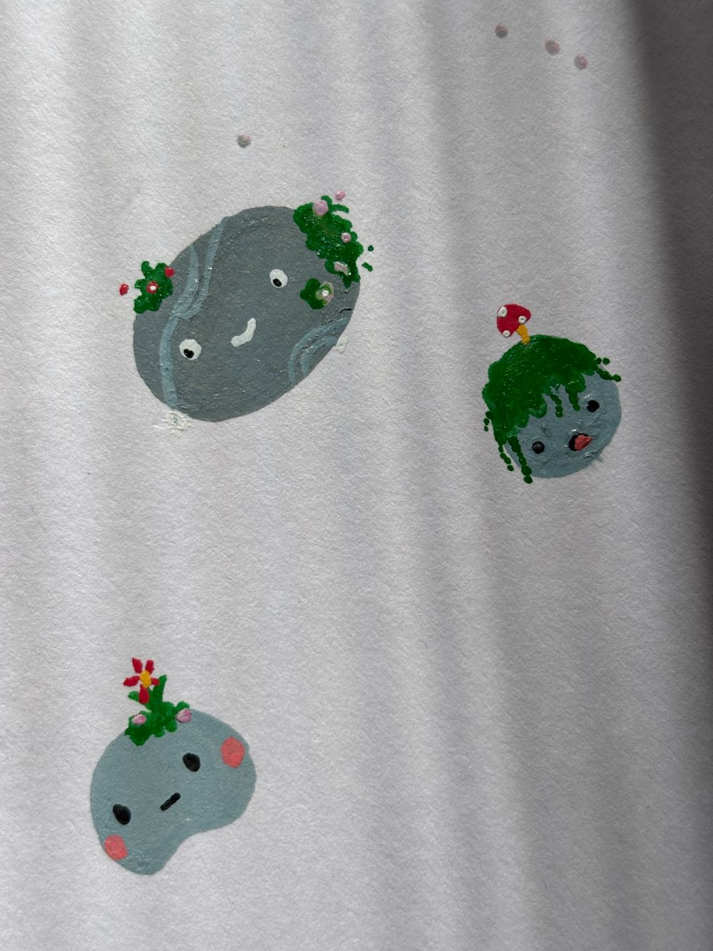 Illustration of smiling stones with moss, flowers and a mushroom